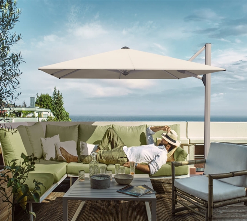 Gentleman sleeping on a green sofa underneath a white umbrella overlooking the ocean Gentleman sleeping on a green sofa underneath a white umbrella overlooking the ocean