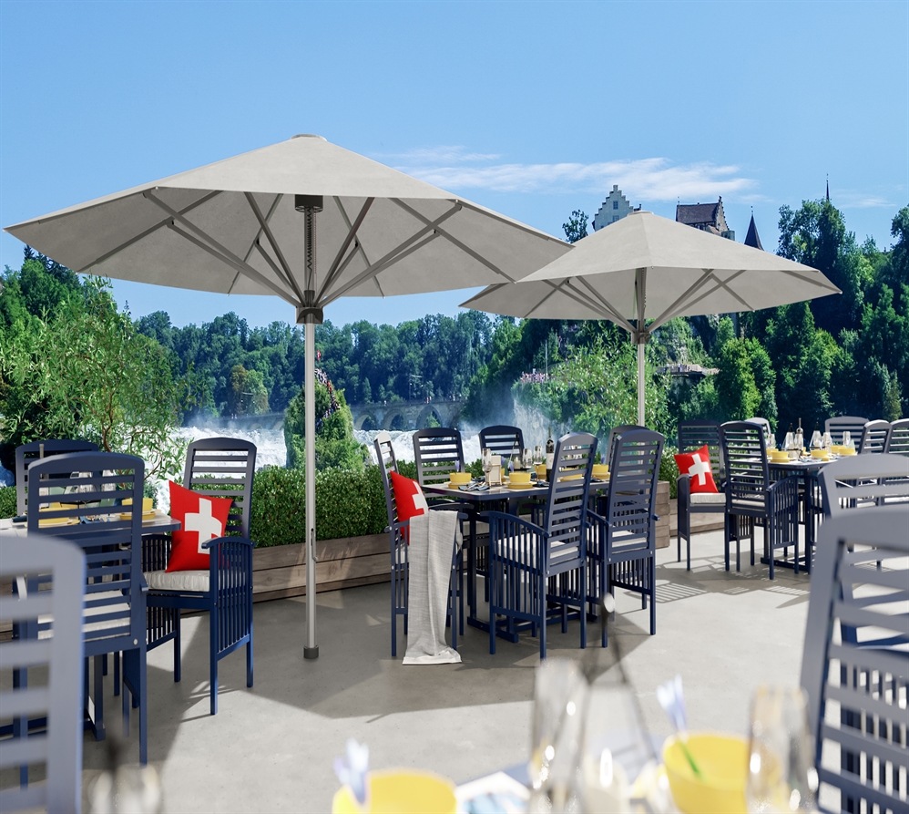 2 large white umbrellas on a restaurant patio overlooking a sea of large trees 2 large white umbrellas on a restaurant patio overlooking a sea of large trees