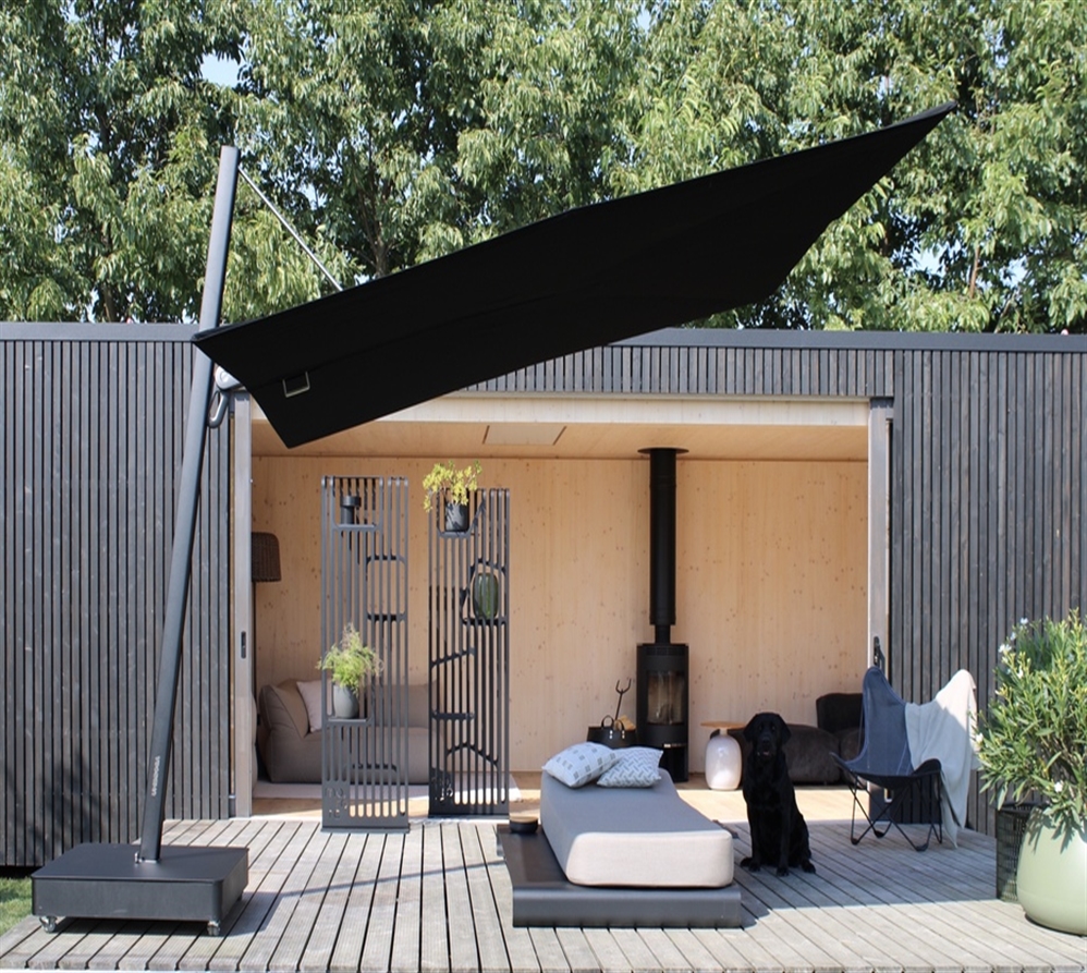 Modern black umbrella by Umbrosa covering a minimalist style patio with a black dog underneath
