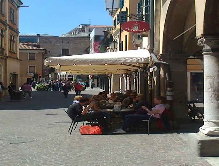 small cream outdoor umbrella installed at a restaurant streetside patio