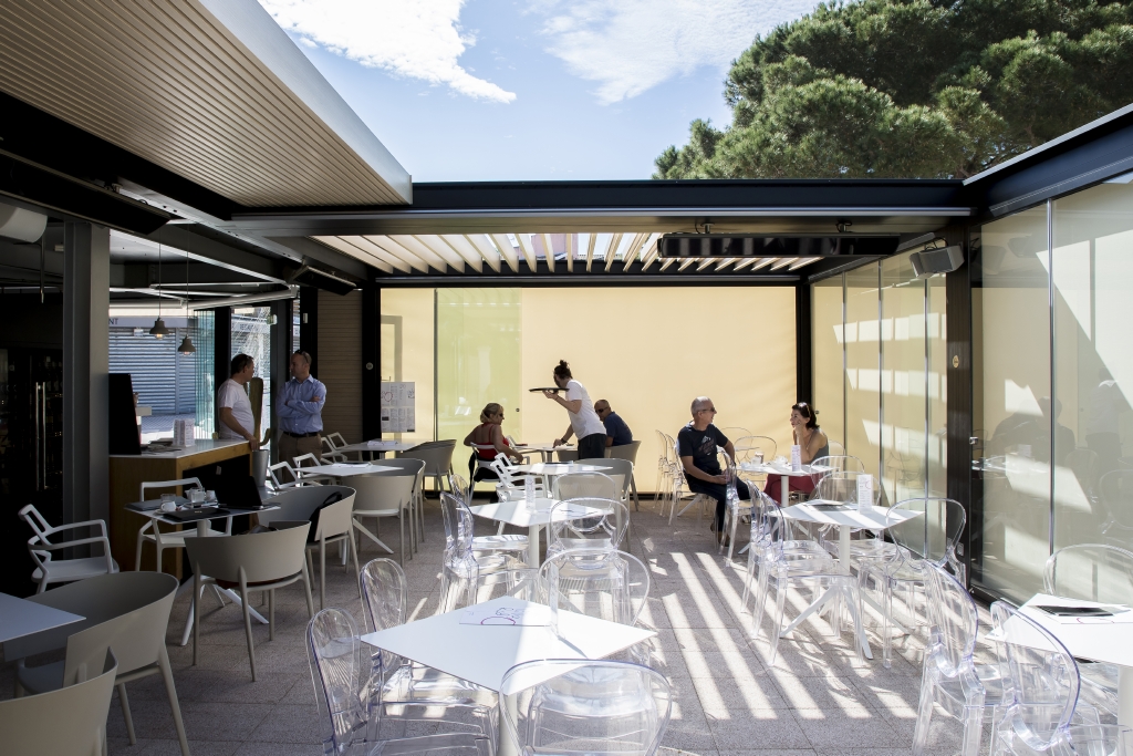 wooden style aluminum louvres in an awning system with retractable screens at a restaurant