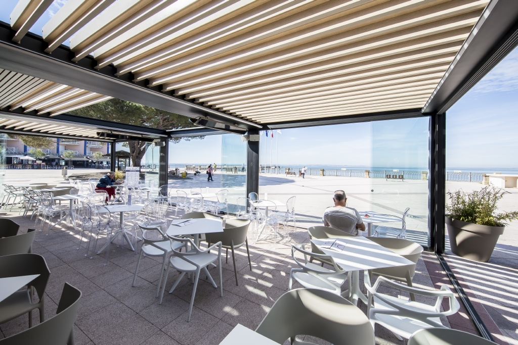 golden wooden aluminum style louvres in a roof system with glass panel enclosures by the beach