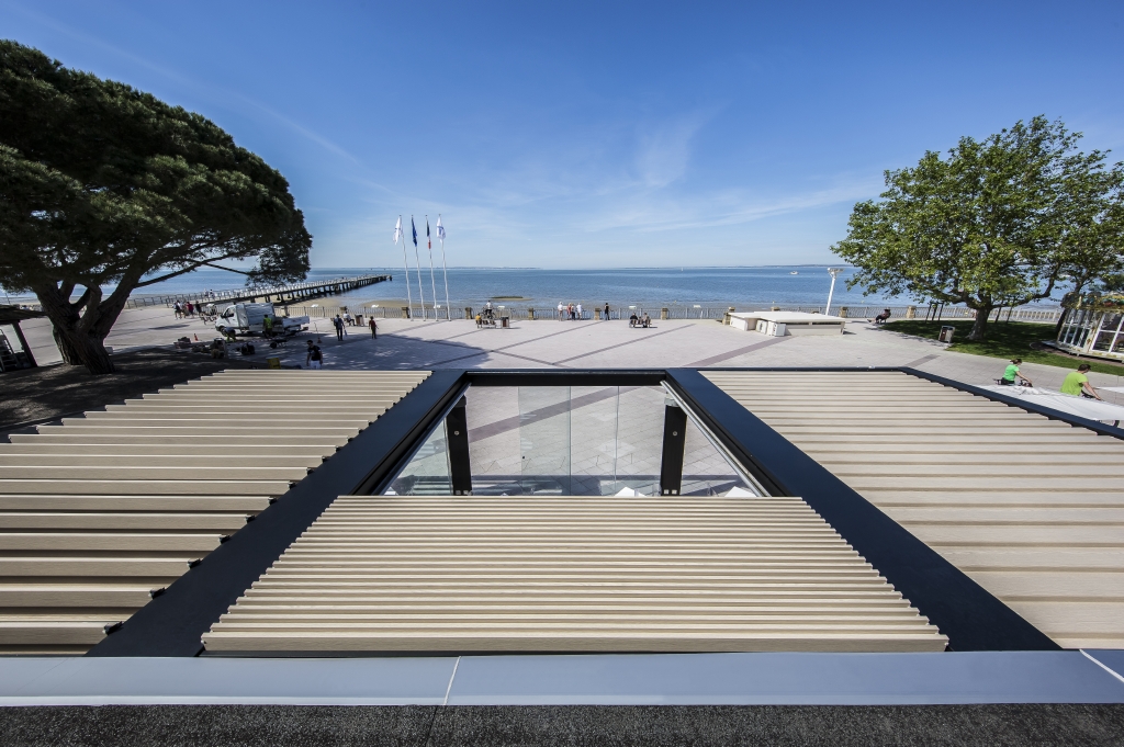 wooden effect aluminum louvres in a pergola system at different positions overlooking a beach