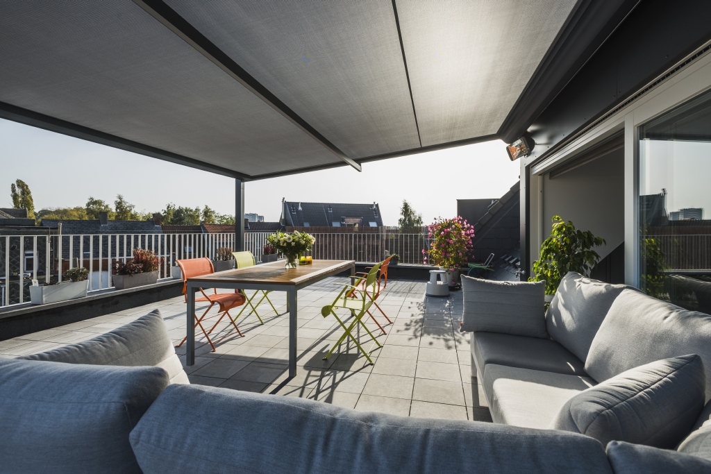 Apartment patio with retractable PVC pergola shading living area Apartment patio with retractable PVC pergola shading living area