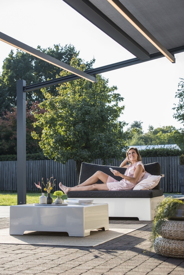 Women operating remote control to fully open PVC pergola Women operating remote control to fully open PVC pergola