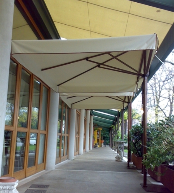 Wood finish side arm cream parasol over patio dining area