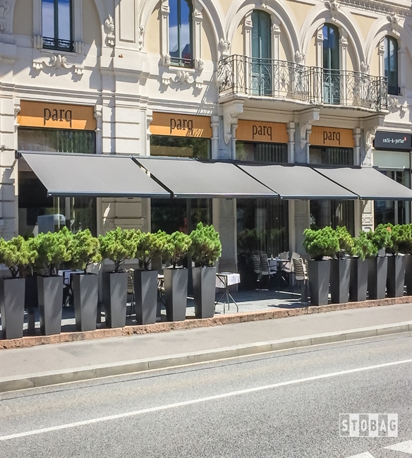 grey fabric awnings attached to a building to cover the restaurant patio