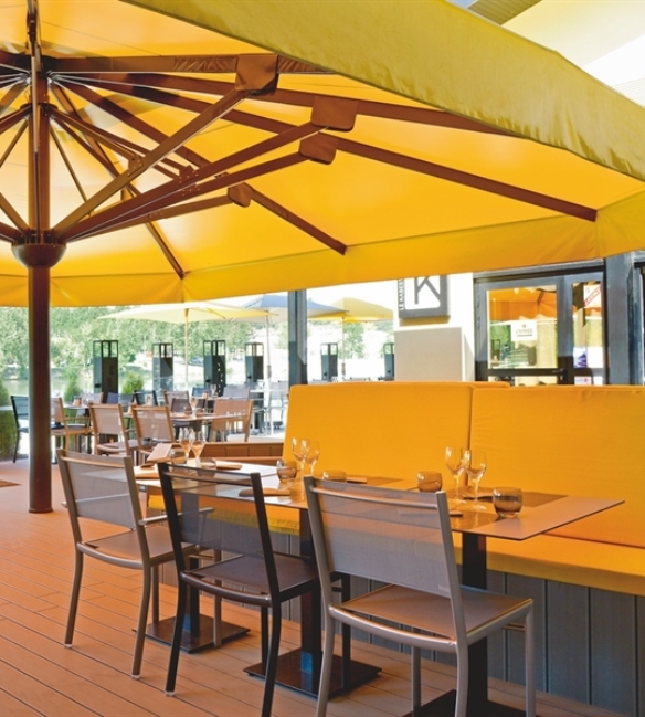 Yellow goliath parasol with wood frame  covering an outdoor patio