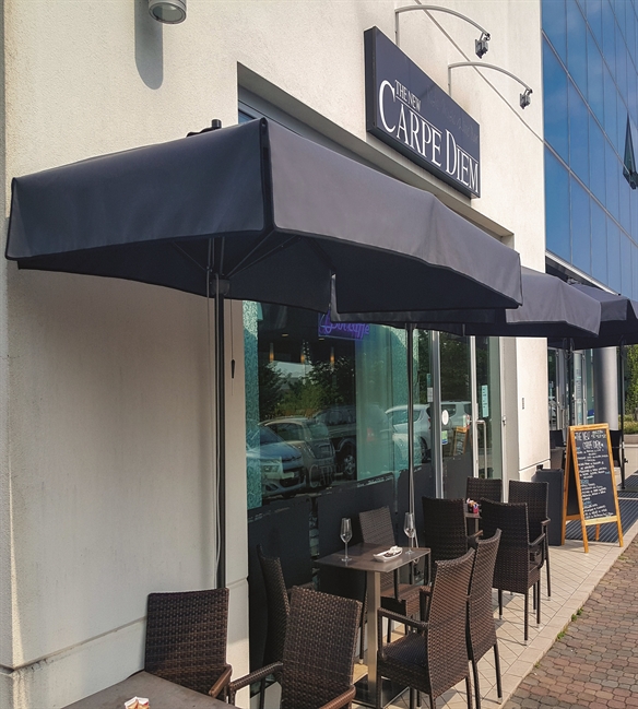 Blue parasols along the wall of café shading their outdoor small seating area