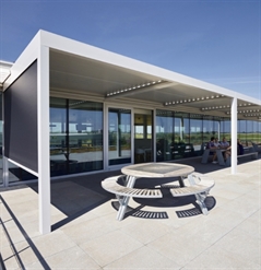 outdoor office lunch area covered with white bioclimatic pergolas enclosed with screens