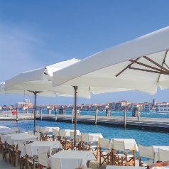 White parasols over seating area of an outdoor dining restaurant on a sunny day