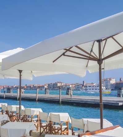 White parasols over patio restaurant along the seaside on a sunny day