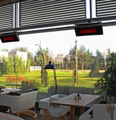 gas heaters attached to the ledge of a restaurant patio ceiling that are turned on