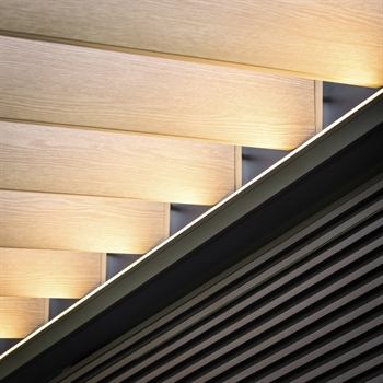 Close up of wood finish aluminum louvers installed in a black pergola