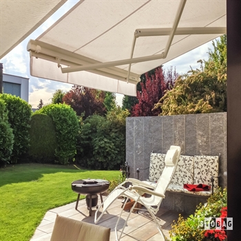 Cream awning extended over an outdoor backyard patio