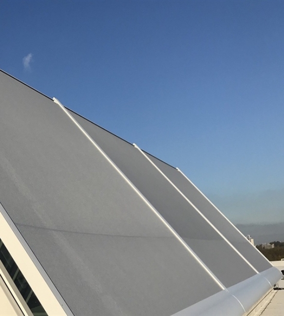 grey external screen installed on the exterior of rooftop windows on a building