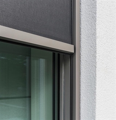 close up details of a automated screen installed outside of a window on a white home