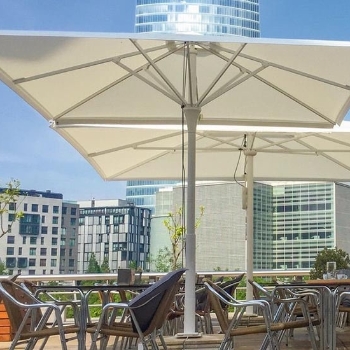 White parasols opened over café seating area