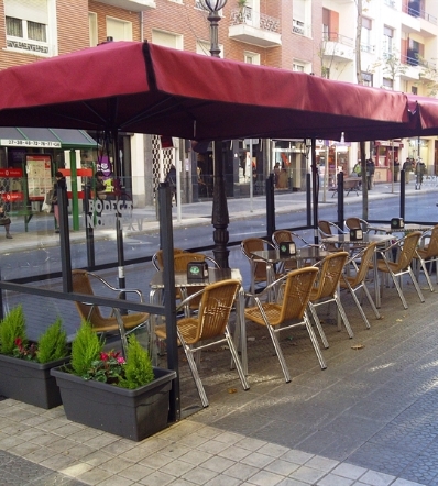 Side by side red side arm parasols shading outdoor restaurant seating area