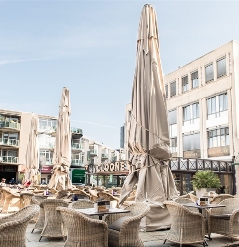 Golia large parasols shown in closed position  at an outdoor café