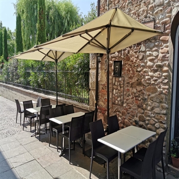 Cream parasols along brick wall of outdoor restaurant seating