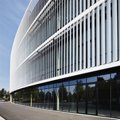 Aluminum louvres installed vertically on three floor building with glass windows