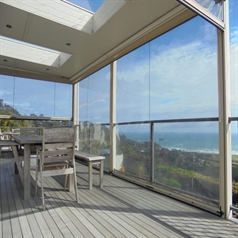 an overhang balcony enclosed with clear pvc screens overlooking the mountains