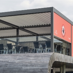 grey bioclimatic pergola with white louvres and enclosed with a red branded screen for a restaurant