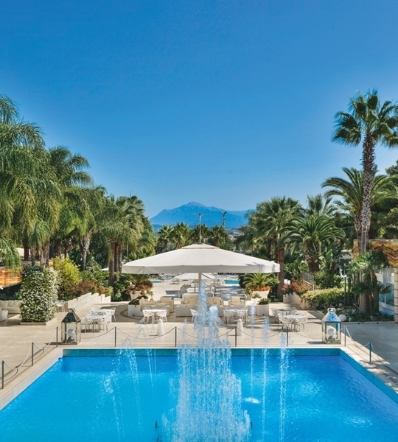 Large Golia parasol opened and shading a poolside lounge area