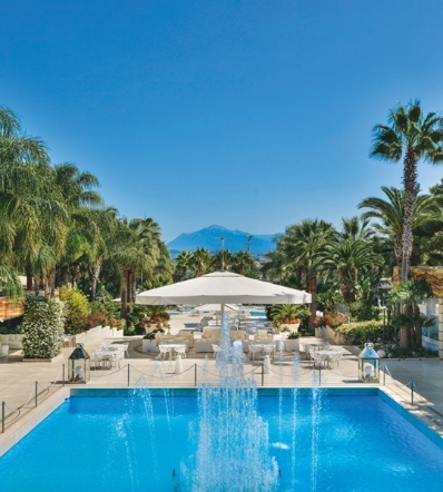 Large Golia parasol opened and shading a poolside lounge area