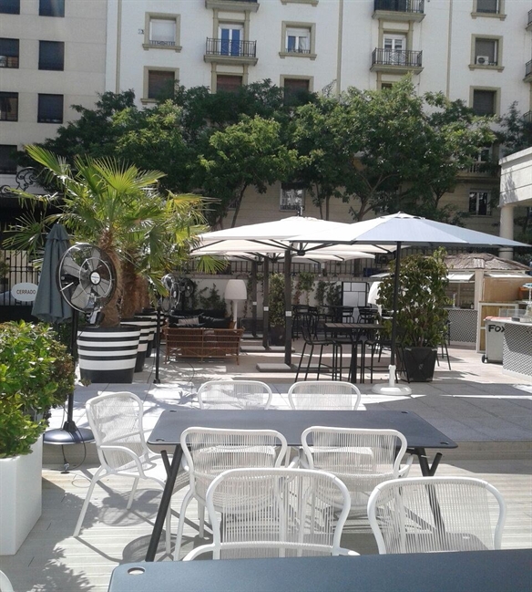 White parasols opened over an outdoor dining restaurant on a sunny day