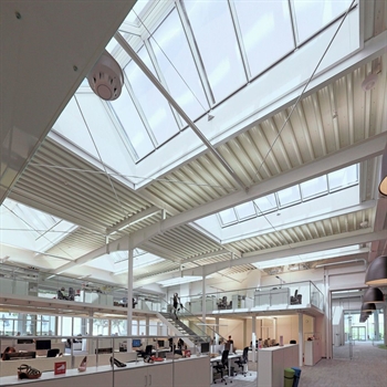 an office building with large skylight windows with sun protection screens on the outside