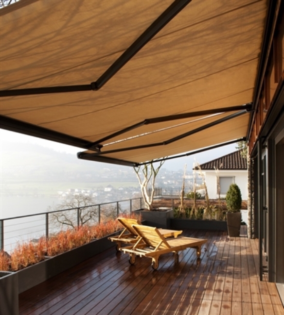 light brown canvas awning hanging over the deck of a residence