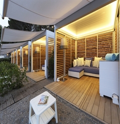 white pergolas with wooden louvred panel enclosures designed as cabana at a resort