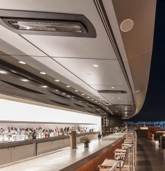 outdoor heaters installed along the ceiling line of a bar on a boat at night time