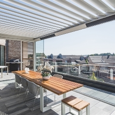 Pergola heaters incorporated into frame of pergola over an apartment patio dining area