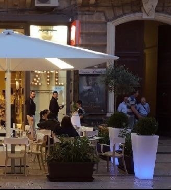 white umbrella situated on a restaurant patio at night time with backlit panels