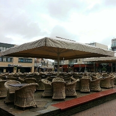 Cream Golia larger parasols covering a large span over outdoor café seating