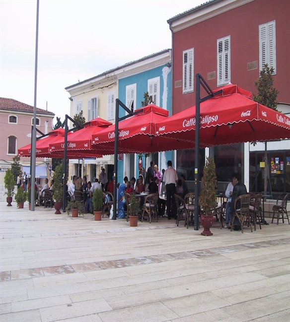 Red logged patio umbrellas over outdoor seating of a restaurant