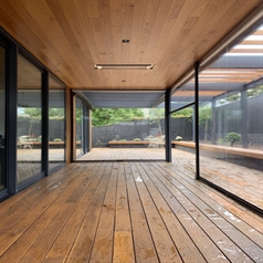 a home with an overhang patio enclosed with clear pvc screens for weather protection