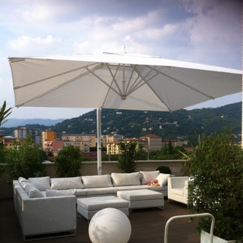 White parasol over white patio furniture on a rooftop patio
