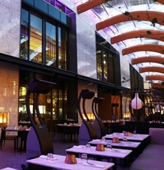 standing heaters next to the tables of an outdoor patio at night