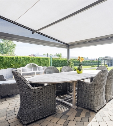 a close up image with a view perched below a white PVC retractable awning in the daytime