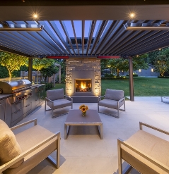 louvred roof system overlooking a modern garden with heaters installed on the frame that are lit