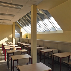 a classroom with skylight windows that have dark sun protection screens installed on the exterior