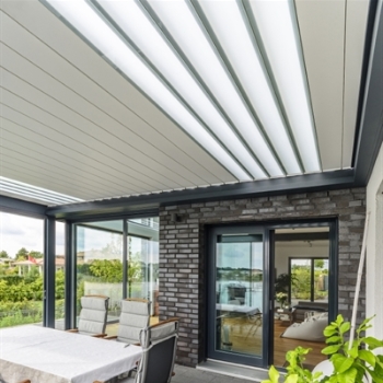 Aluminum retractable louvered pergola with translucent glass blades incorporated into the louvers