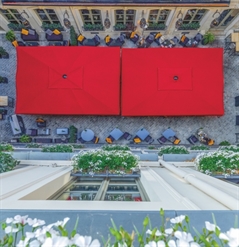 birds eye view of 2 large red patio umbrellas covering a communal gathering space