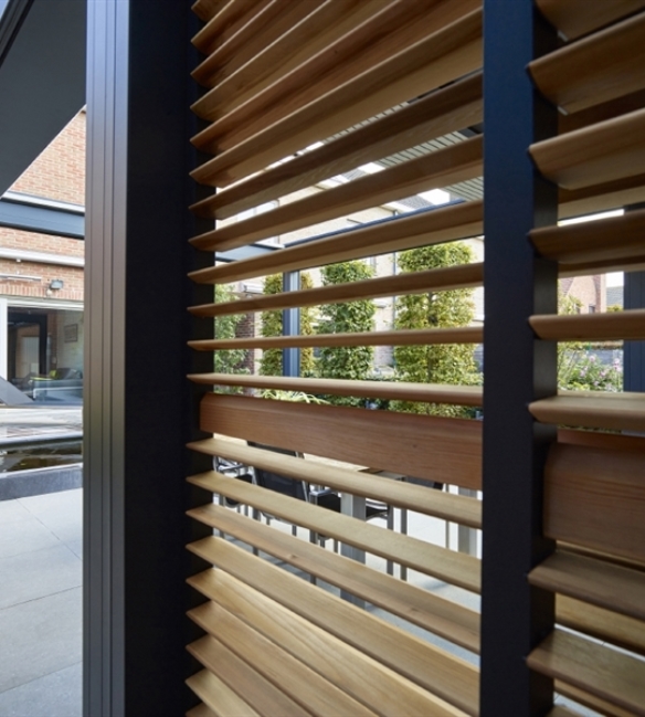 Loggia sliding panels with wood slats that tilt and close used for patio enclosure