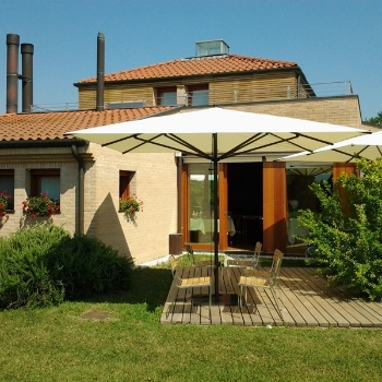 Centre pole cream parasol over a homes patio area in the backyard