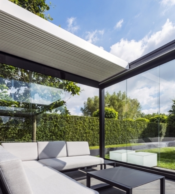 Glass panels added to the sides of an aluminum retractable pergola of an outdoor living patio area